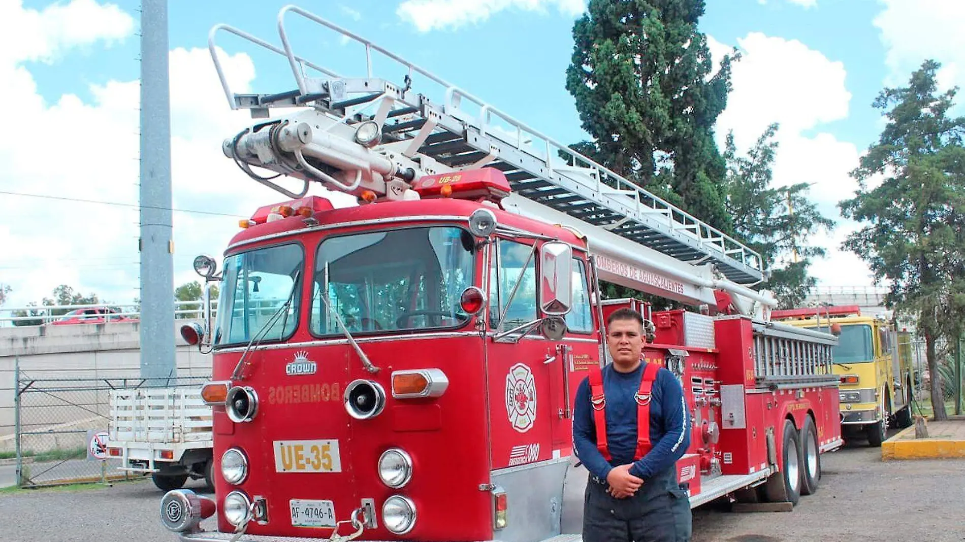 bombero posa frente a camionde bomberos